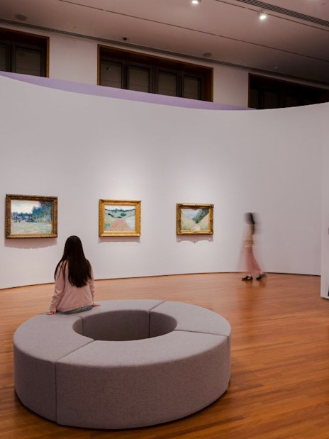 Tourists viewing impressionist paintings at National Gallery Singapore.