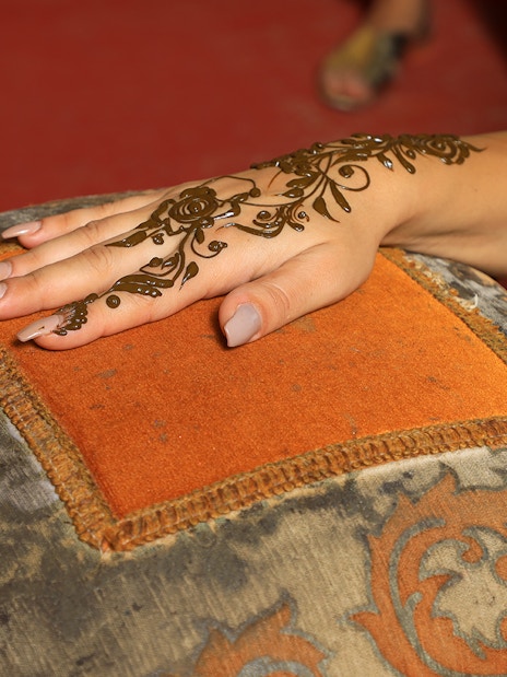 Henna design being applied on a hand during Arabian Dunes Premium Safari.