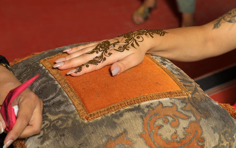 Henna design being applied on a hand during Arabian Dunes Premium Safari.