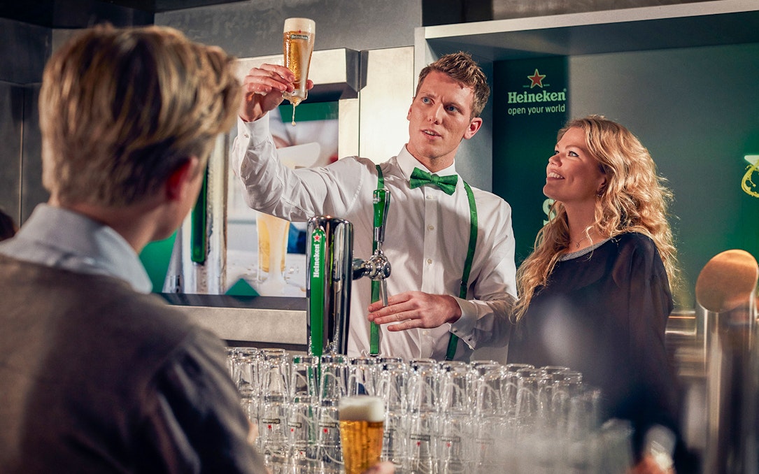 Heineken brewery guide showing beer to visitors inside the brewery.