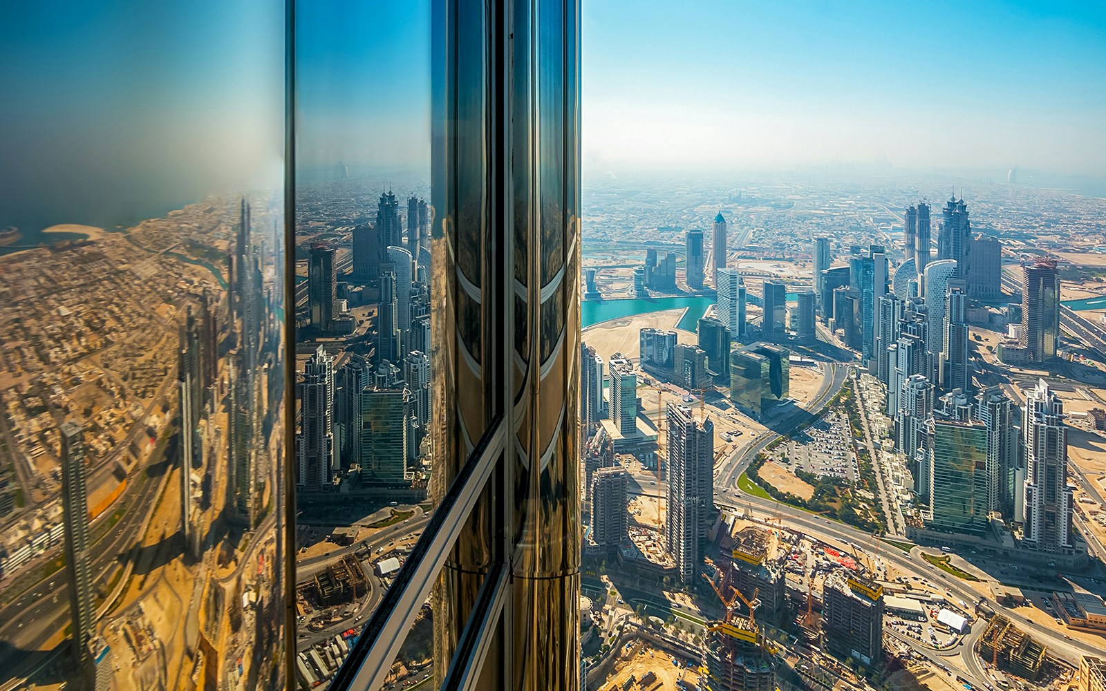 View of Downtown Dubai from Burj Khalifa observation deck, showcasing skyscrapers and cityscape.