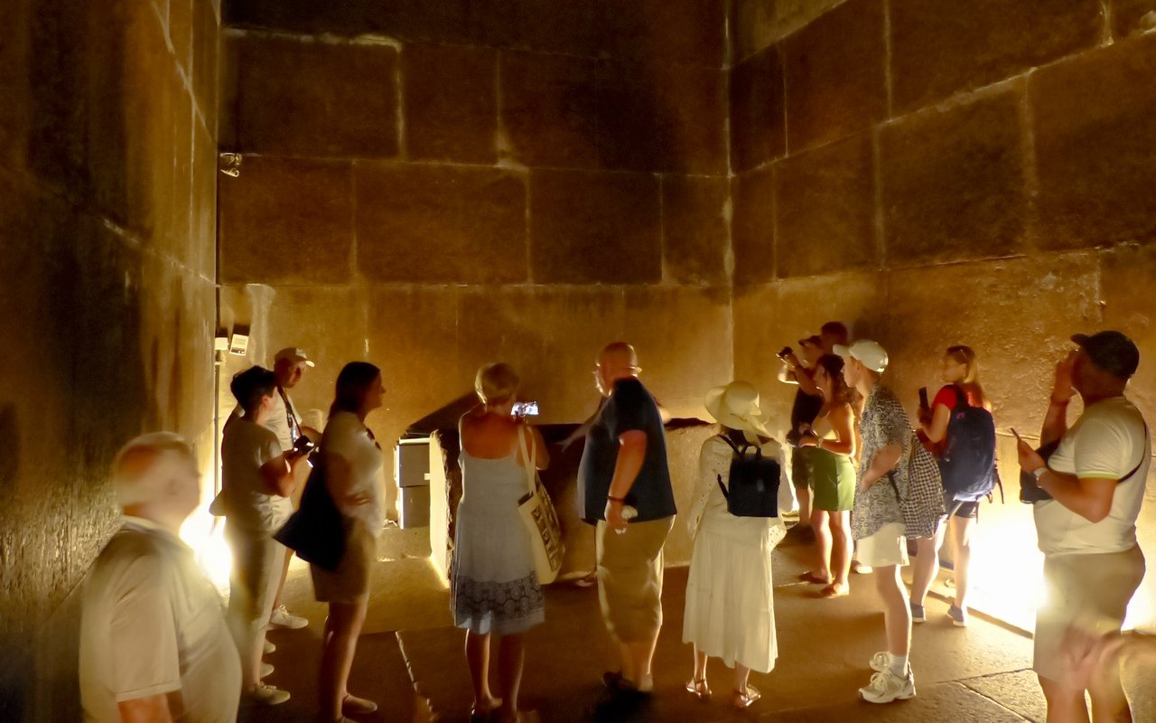 Visitors exploring an ancient chamber at the Grand Egyptian Museum.