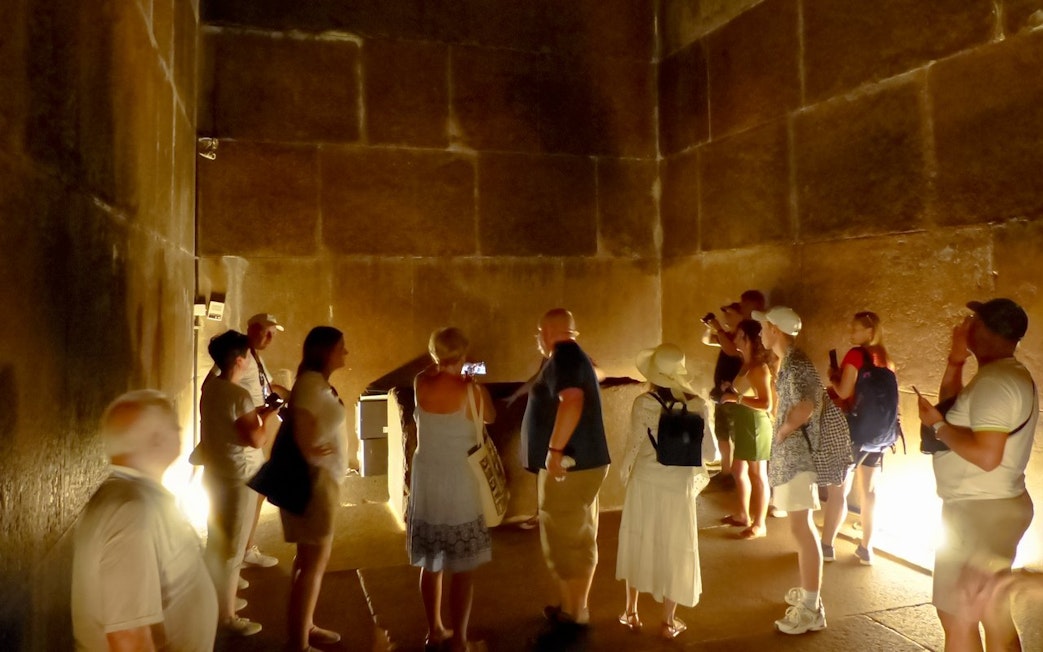 Visitors exploring an ancient chamber at the Grand Egyptian Museum.