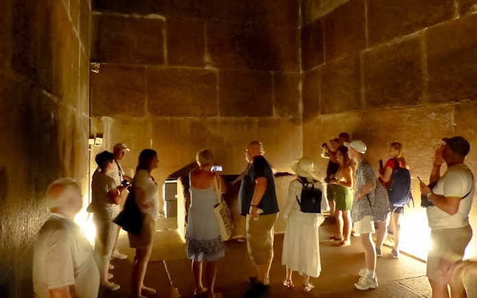 Visitors exploring an ancient chamber at the Grand Egyptian Museum.