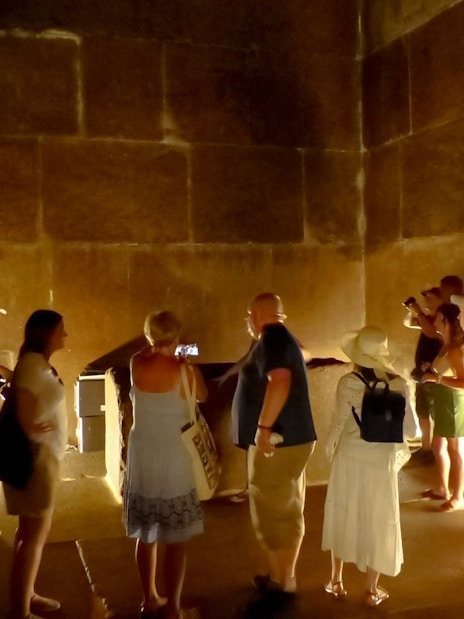 Visitors exploring an ancient chamber at the Grand Egyptian Museum.