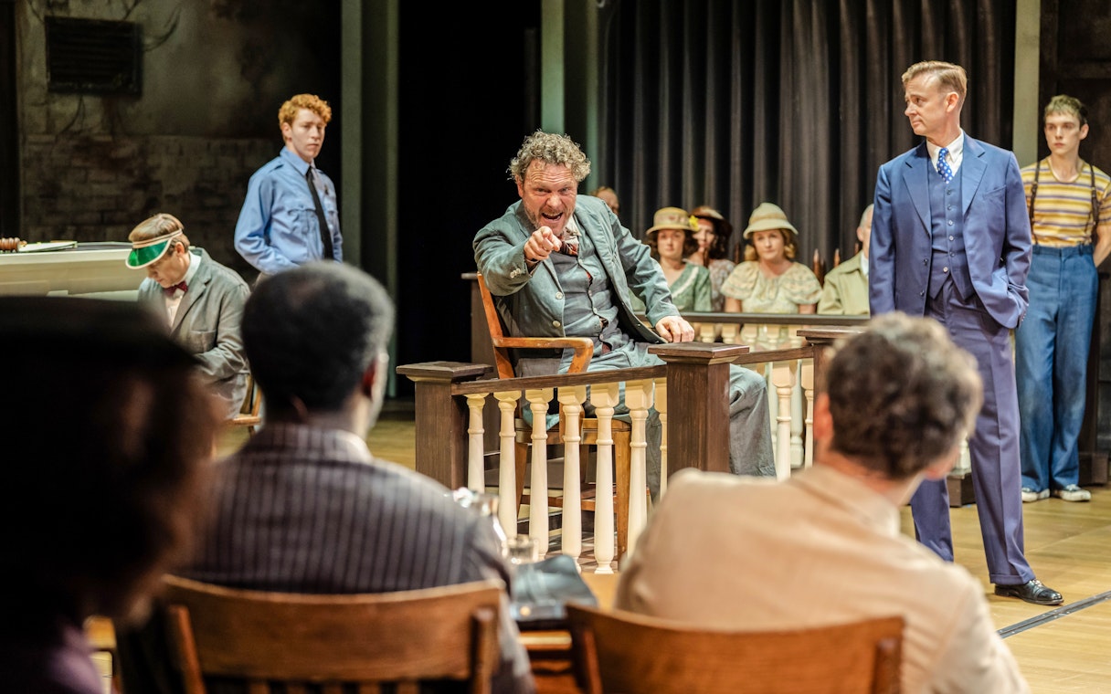 Courtroom scene from "To Kill a Mockingbird" West End show, actor pointing from witness stand.