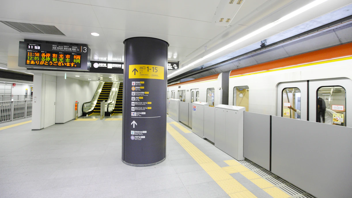 Train platform at Wako-shi Station, Tokyo, Japan, with escalator and train doors open.