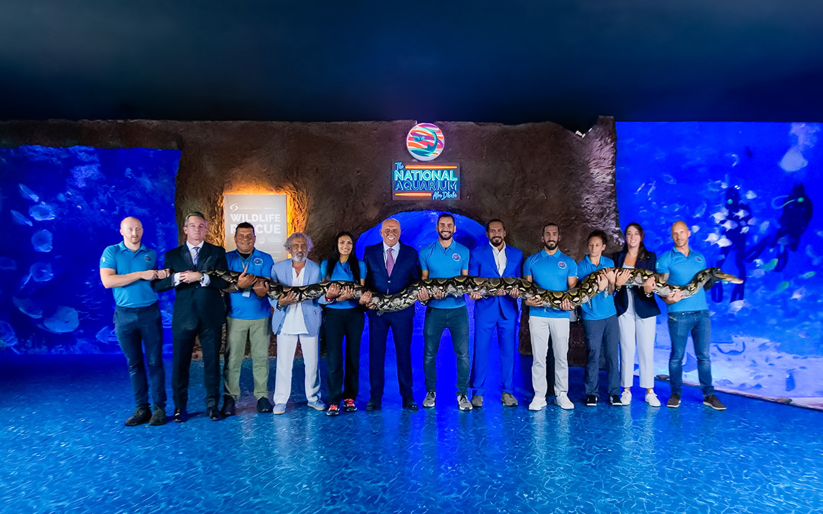 Staff holding a large snake at the National Aquarium Abu Dhabi.