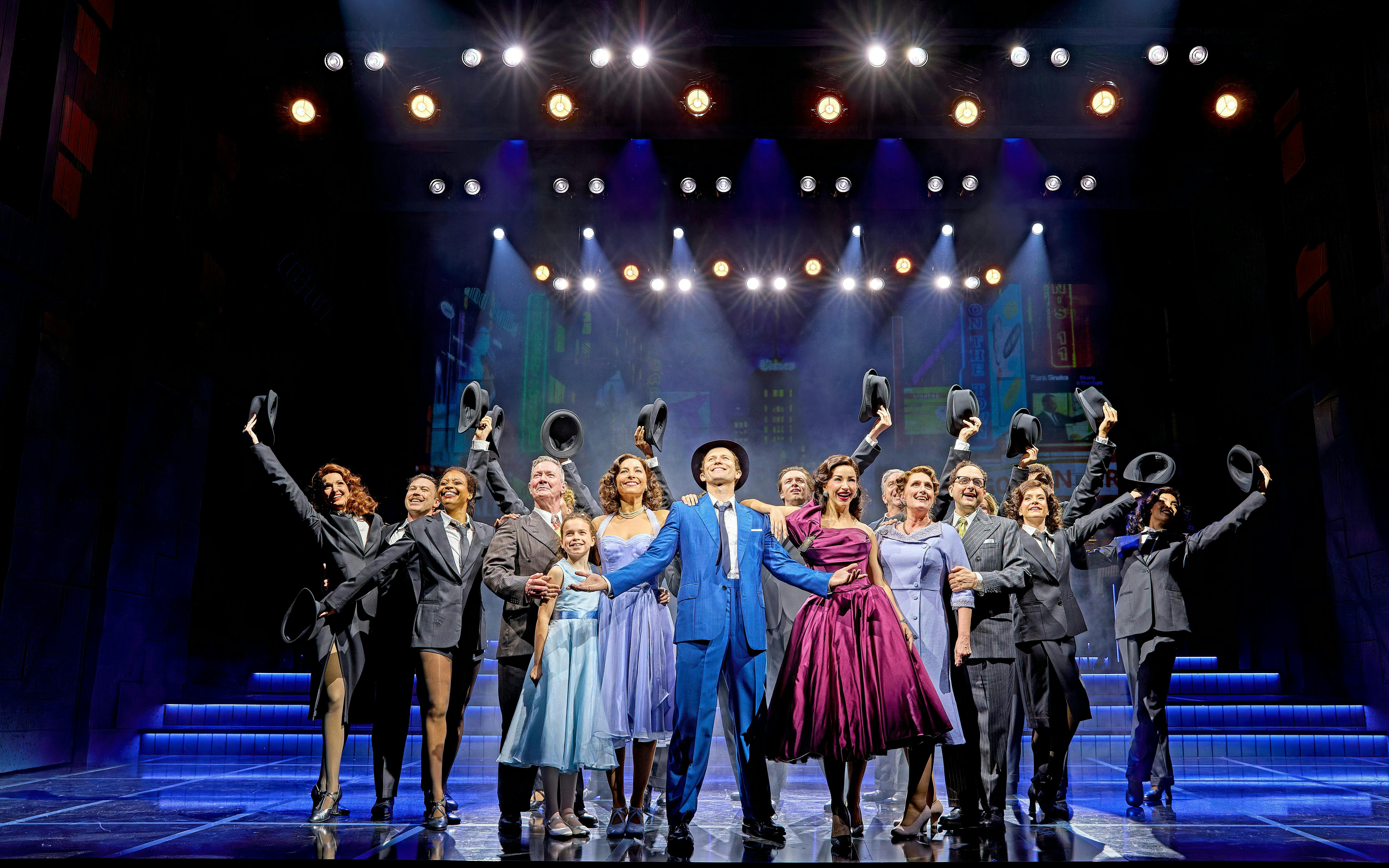 Cast of "Sinatra The Musical" performing on West End stage, holding hats and smiling.