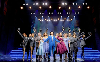 Cast of "Sinatra The Musical" performing on West End stage, holding hats and smiling.