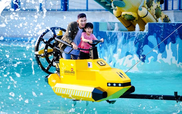 Father and child enjoying Aquazone Wave Racers ride at Legoland Malaysia.