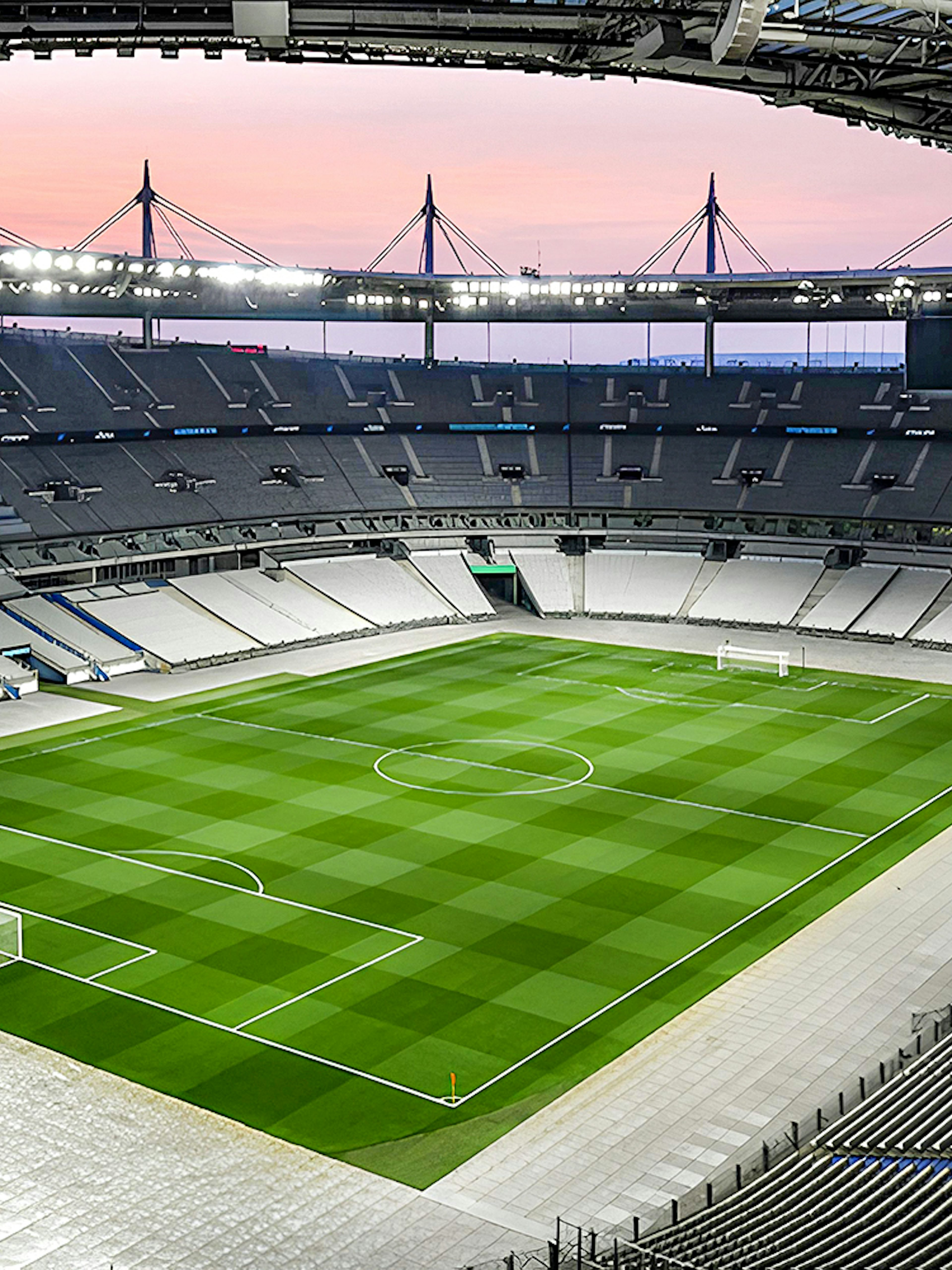 Aerial view of Stade de France stadium with empty seats and green field.