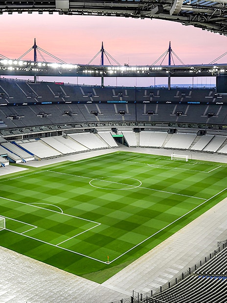 Aerial view of Stade de France stadium with empty seats and green field.