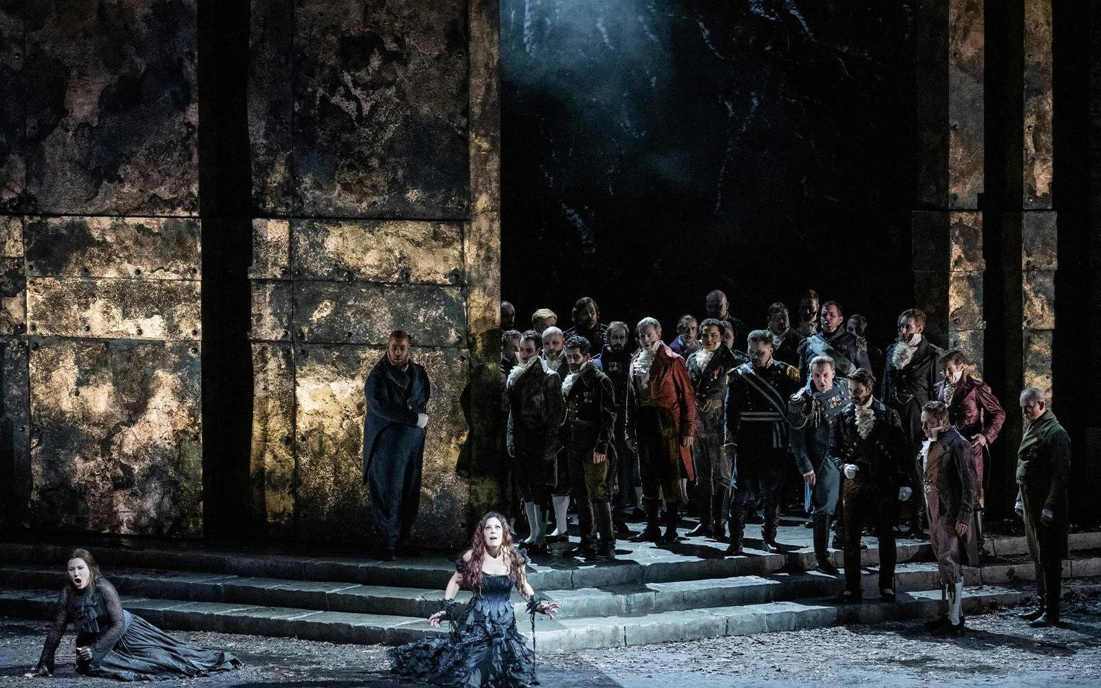 Actors performing Medea on a Broadway stage with a dramatic backdrop.