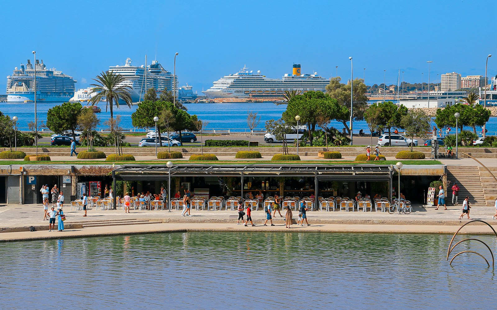 Passeig Marítim Els Molins promenade with palm trees and ocean view in Mallorca.