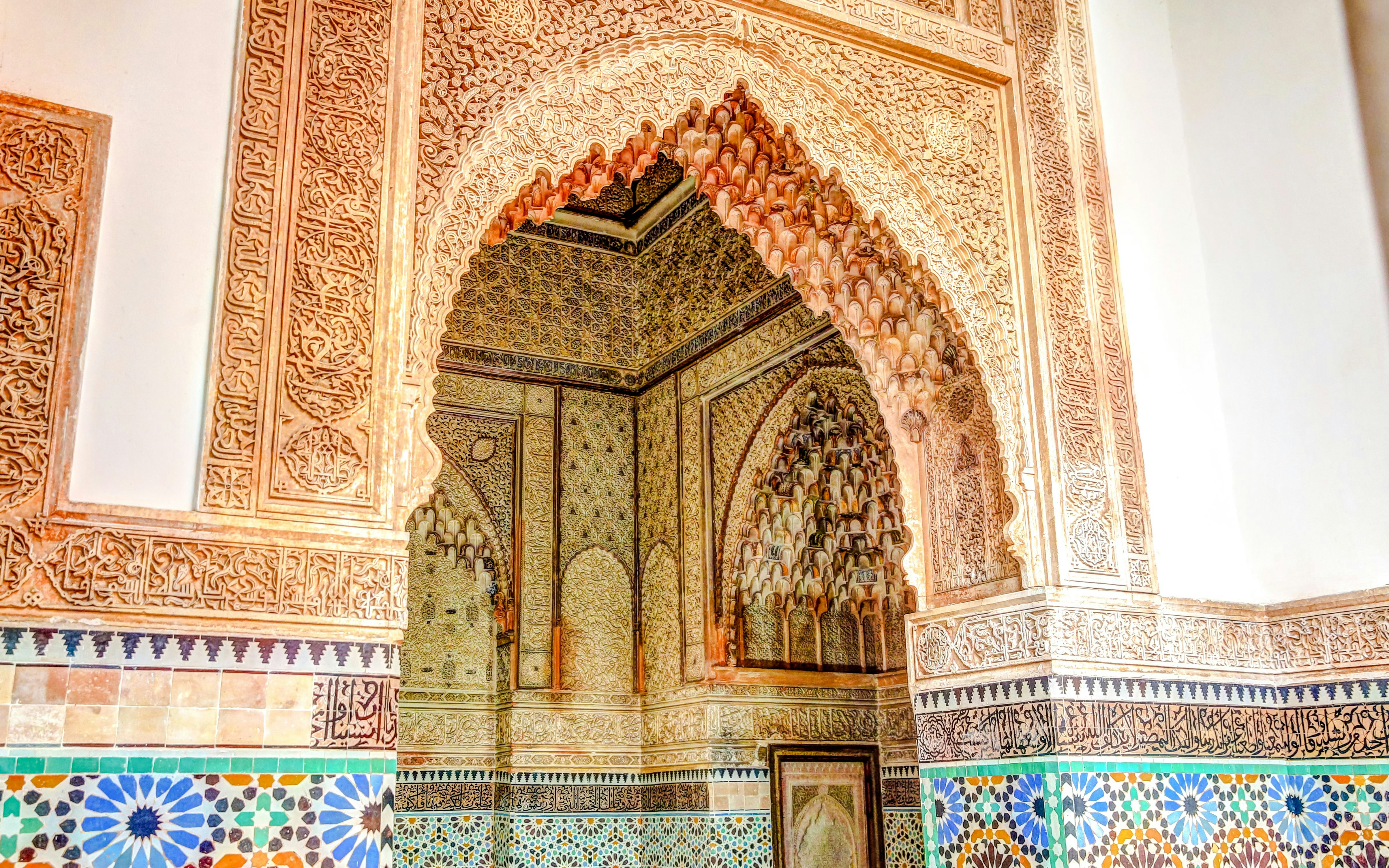 Ornate archway with intricate carvings and colorful tiles at Saadian Tombs, Marrakech.