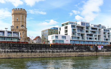 Cologne riverside with historic tower and modern buildings on skyline tour.