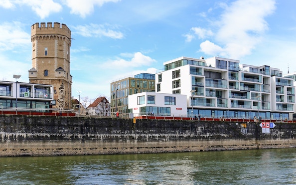 Cologne riverside with historic tower and modern buildings on skyline tour.