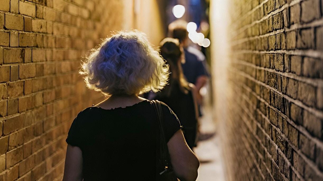Visitors walking through narrow alley on Harry Potter film locations tour in London.