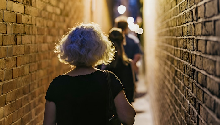 Visitors walking through narrow alley on Harry Potter film locations tour in London.