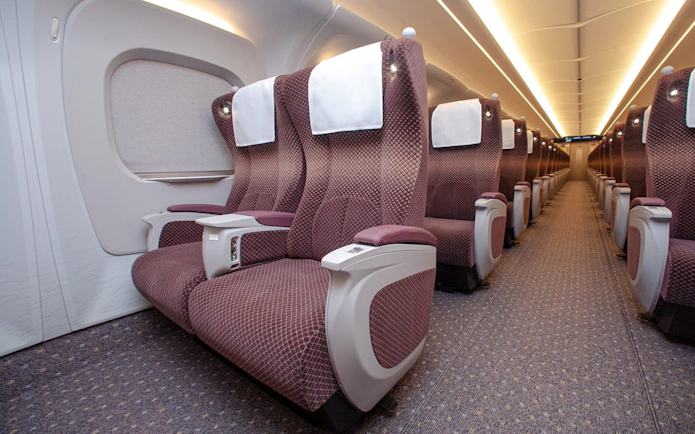 Comfortable seating inside Shinkansen train with spacious aisle.