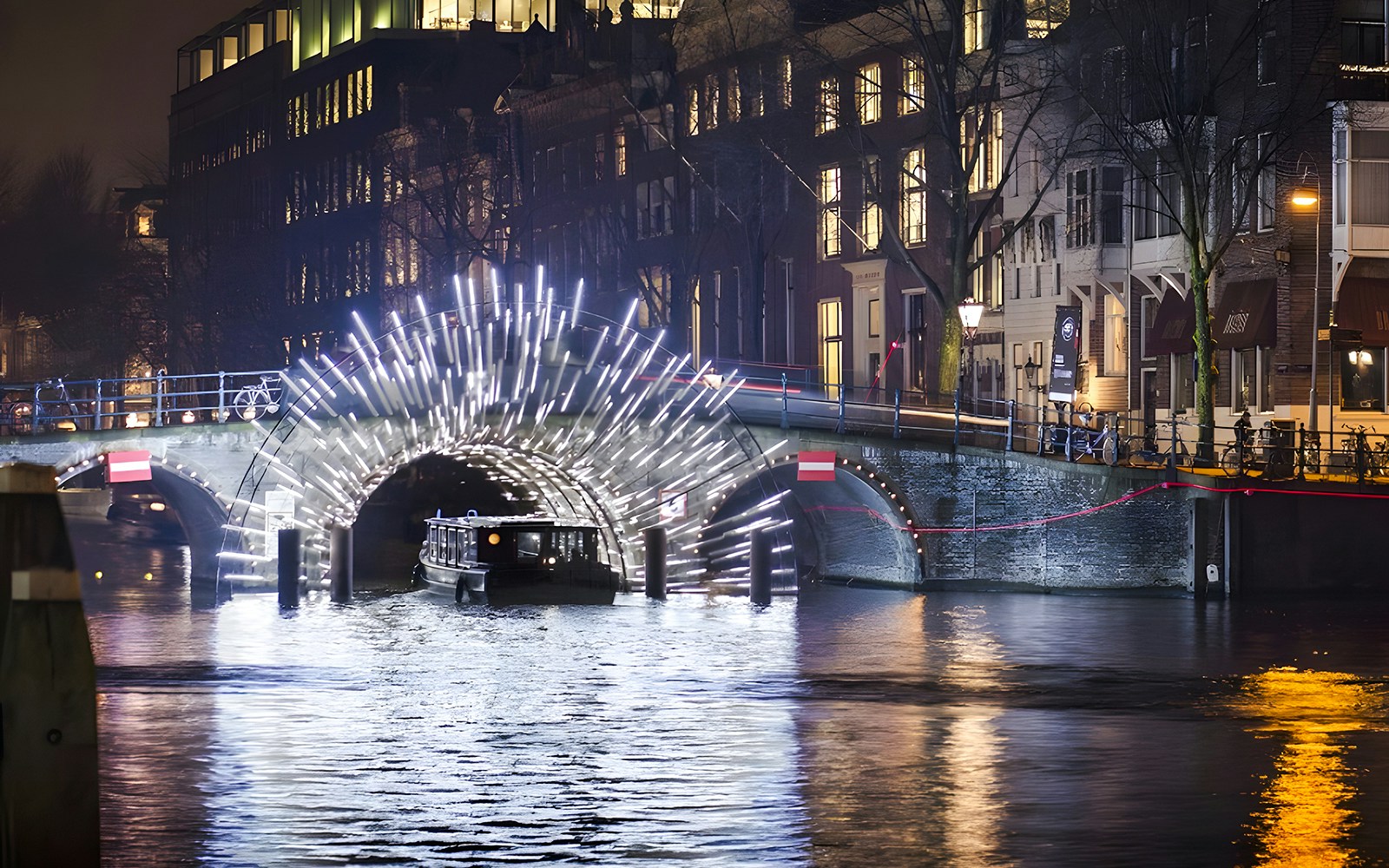 Cruise boat under illuminated arch at Amsterdam Light Festival.