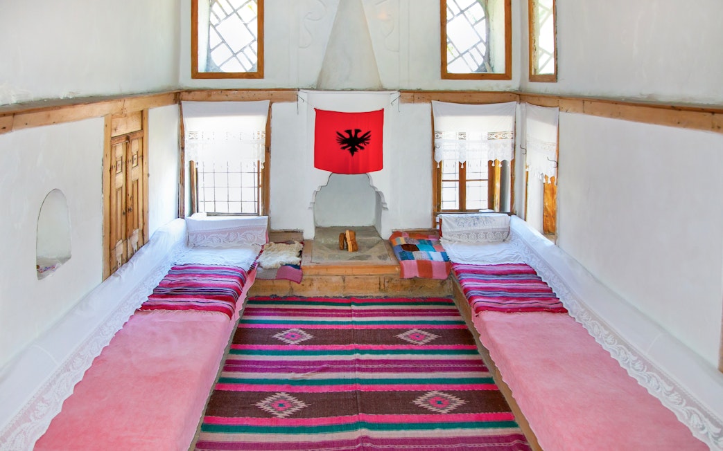 Traditional Albanian room with colorful rugs and benches inside ethnographic museum, Kruje, Albania.
