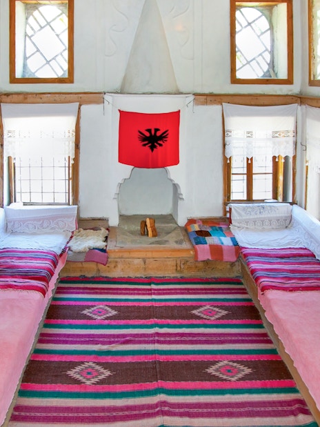 Traditional Albanian room with colorful rugs and benches inside ethnographic museum, Kruje, Albania.