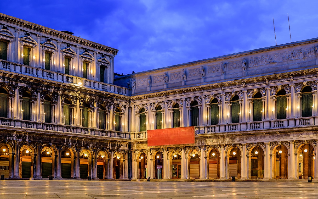 Venice's Museo Correr facade illuminated at dusk, part of the Venice Museums Pass.
