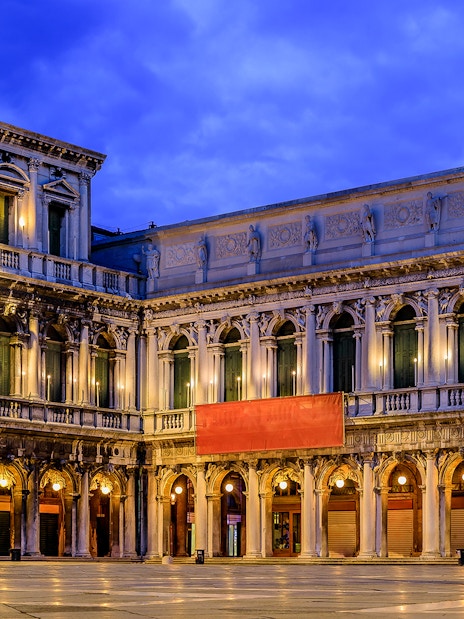 Venice's Museo Correr facade illuminated at dusk, part of the Venice Museums Pass.