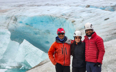 Trekking group on Ojo del Albino Glacier, Argentina, with ice formations in the background.