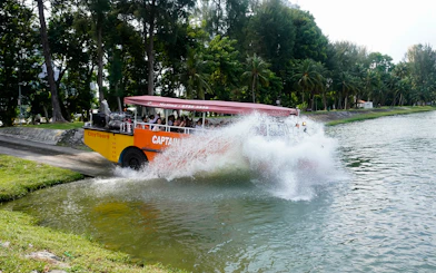 Amphibious vehicle splashing into water during Captain Explorer DUKW Tour in Singapore.