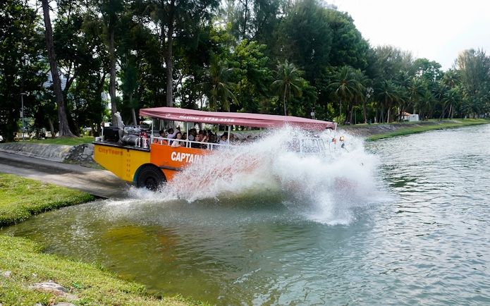 Amphibious vehicle splashing into water during Captain Explorer DUKW Tour in Singapore.