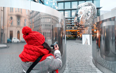 Tourist photographing Franz Kafka sculpture in Prague.