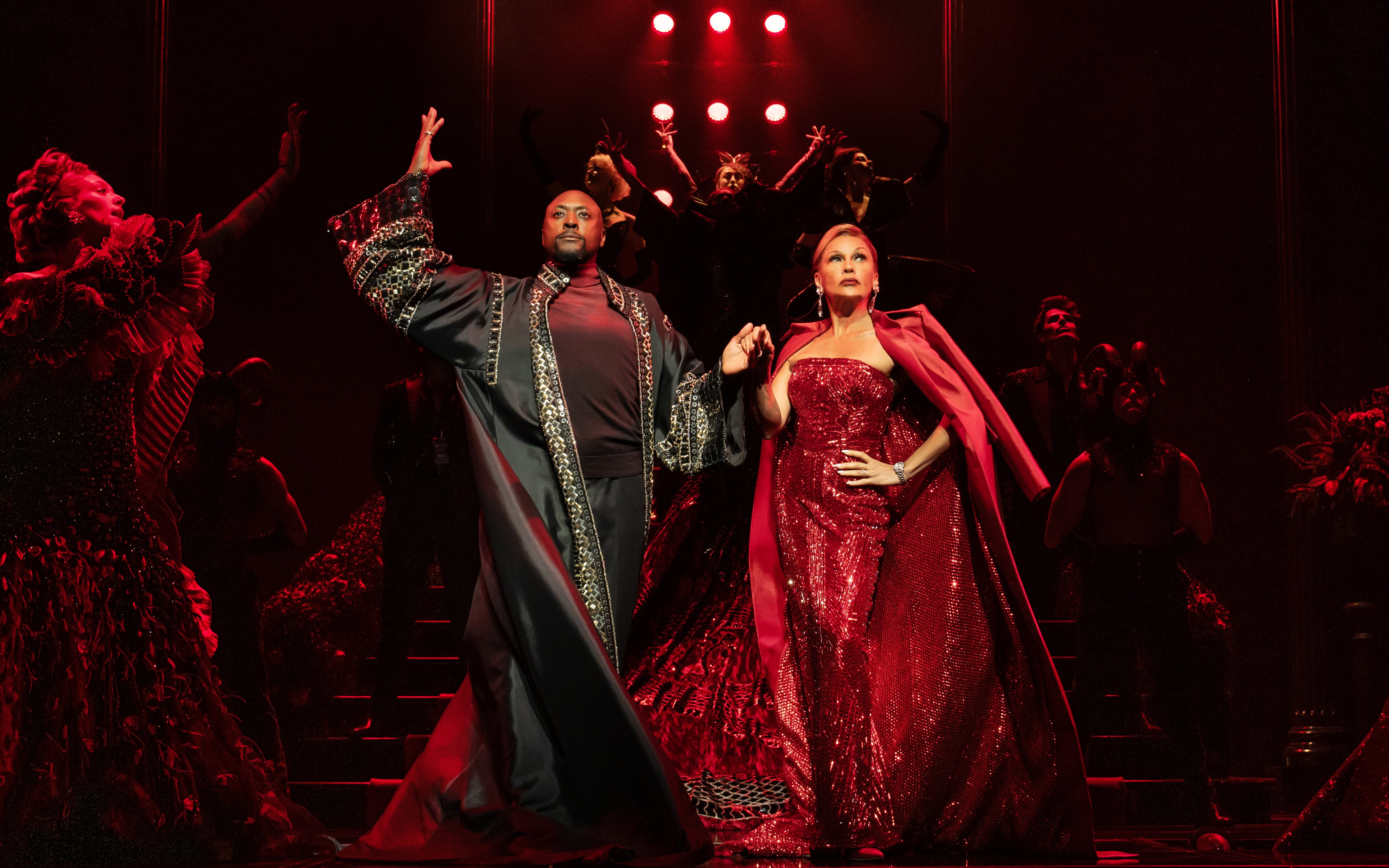 Stage performance of The Devil Wears Prada West End show with actors in elaborate costumes.