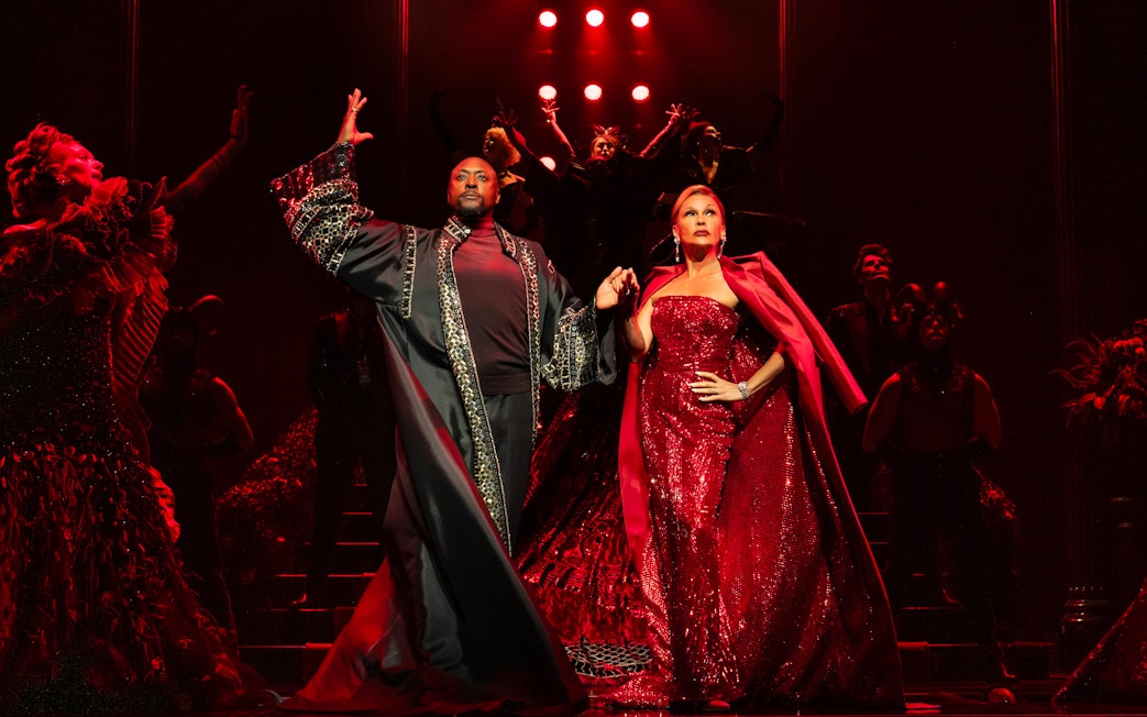 Stage performance of The Devil Wears Prada West End show with actors in elaborate costumes.