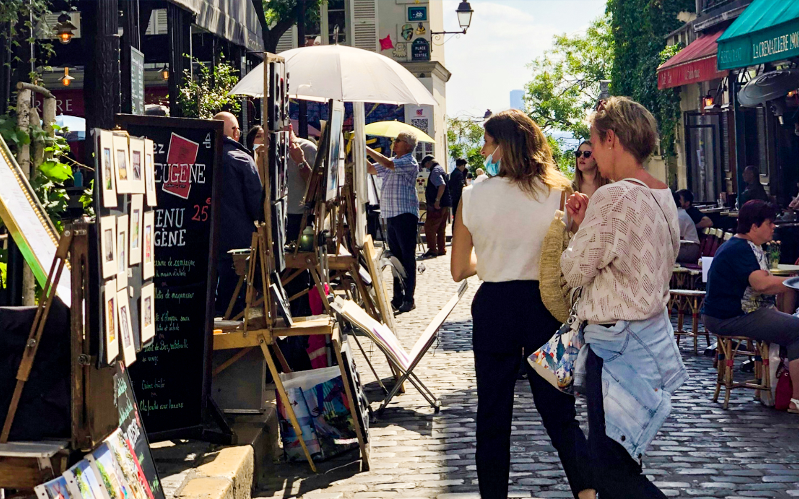 Tourists exploring Montmartre art market on a walking tour in Paris.