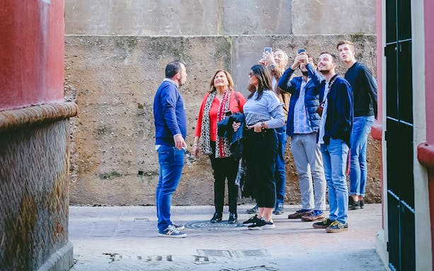 Group on a guided tour in the Jewish Quarter, listening to a guide.