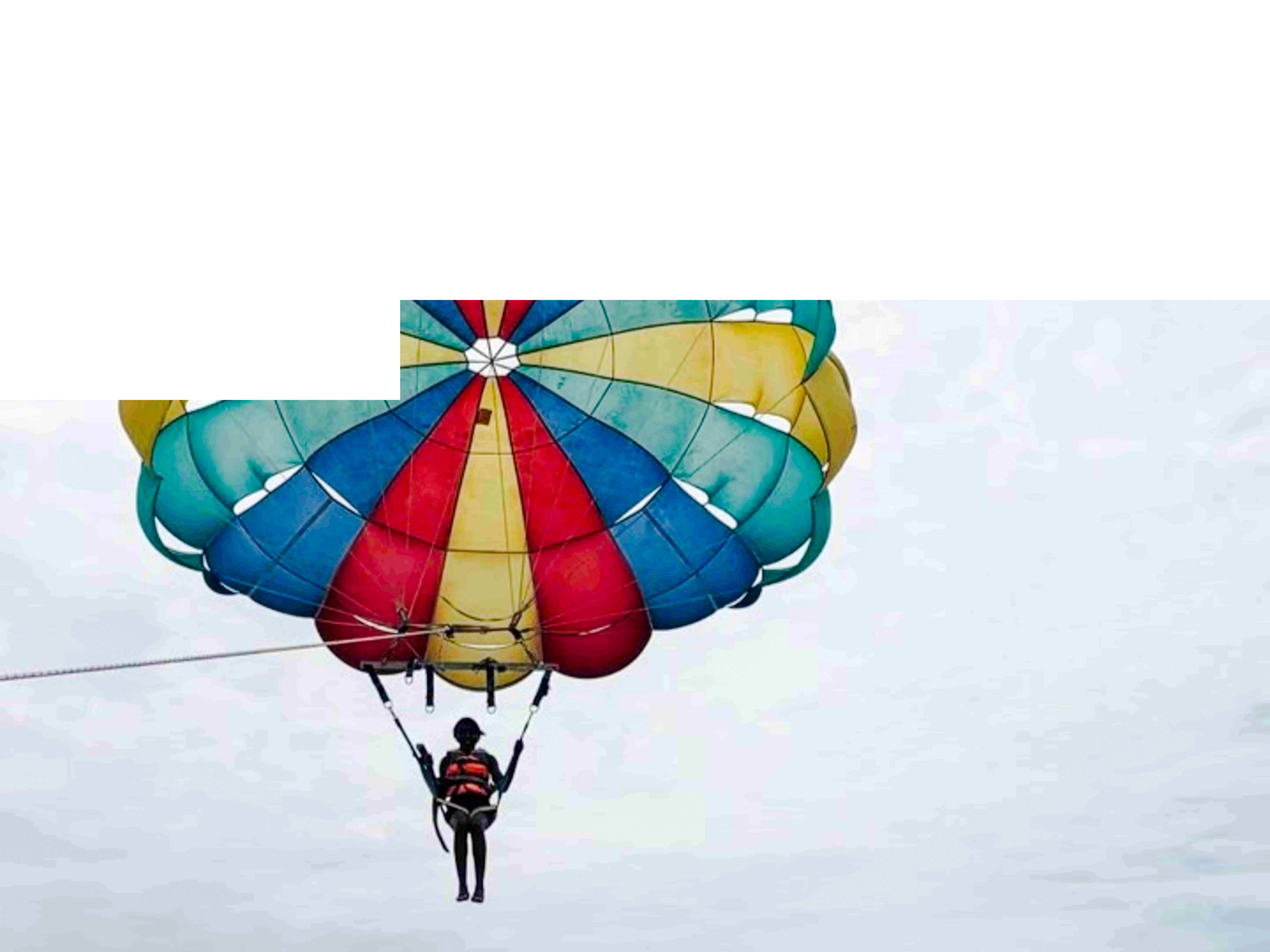 Parasailing over the Indian Ocean in Zanzibar with colorful parachute.
