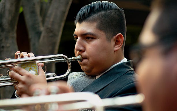 Mariachi musician playing trumpet during Mexico City night tour.