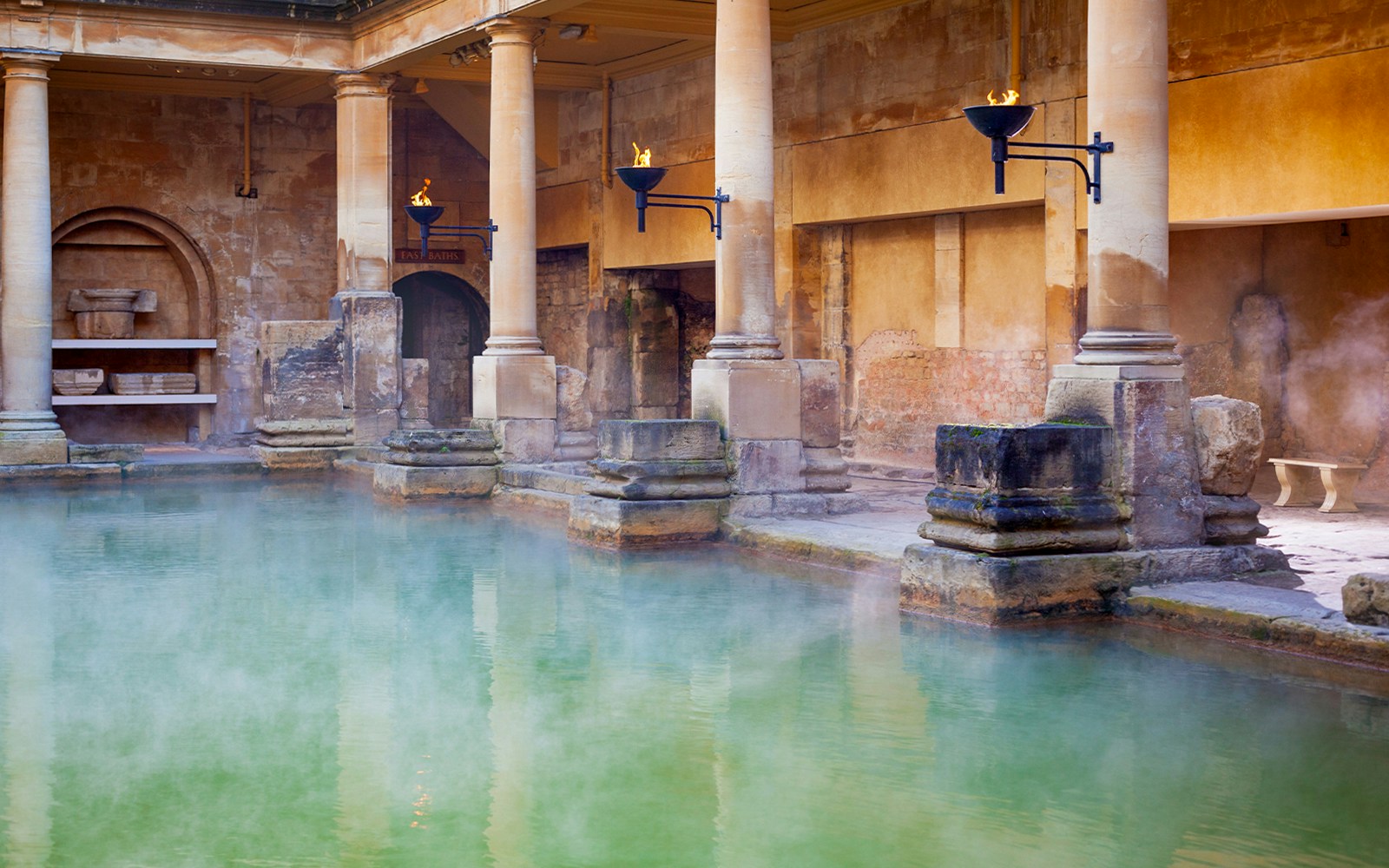 Roman Baths with steaming water and ancient stone columns in Bath, England.