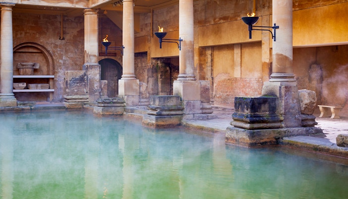 Roman Baths with steaming water and ancient stone columns in Bath, England.