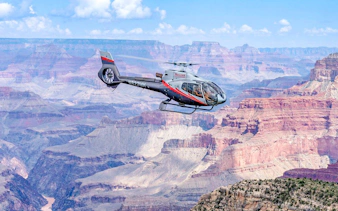 Helicopter flying over Grand Canyon South Rim during scenic tour.