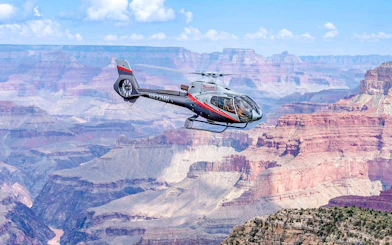 Helicopter flying over Grand Canyon South Rim during scenic tour.
