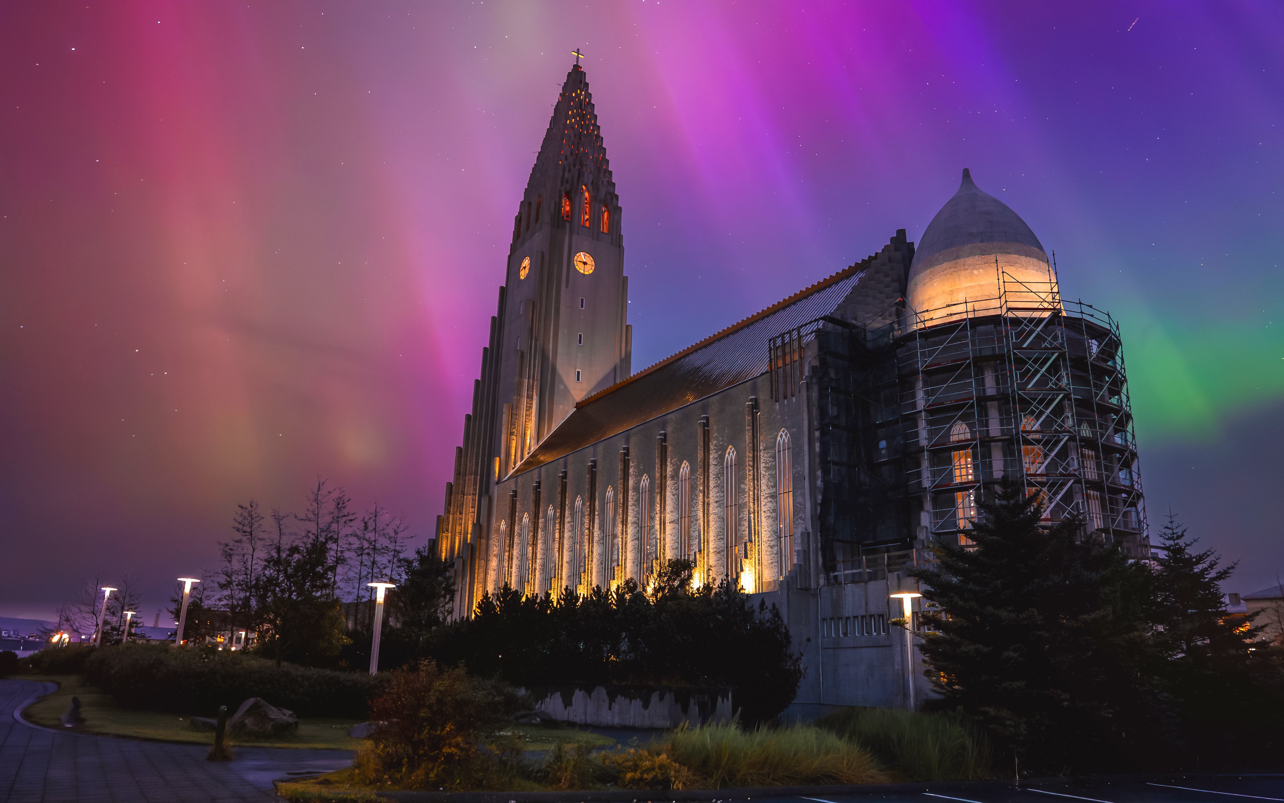 Illuminated church tower under green aurora in Reykjavik, Iceland.