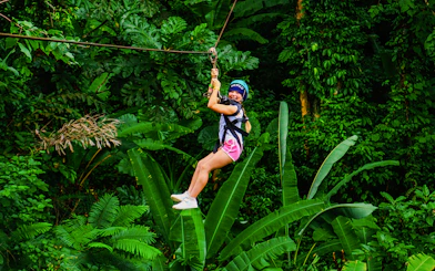 Zip lining through lush forest at Hanuman World, Thailand.