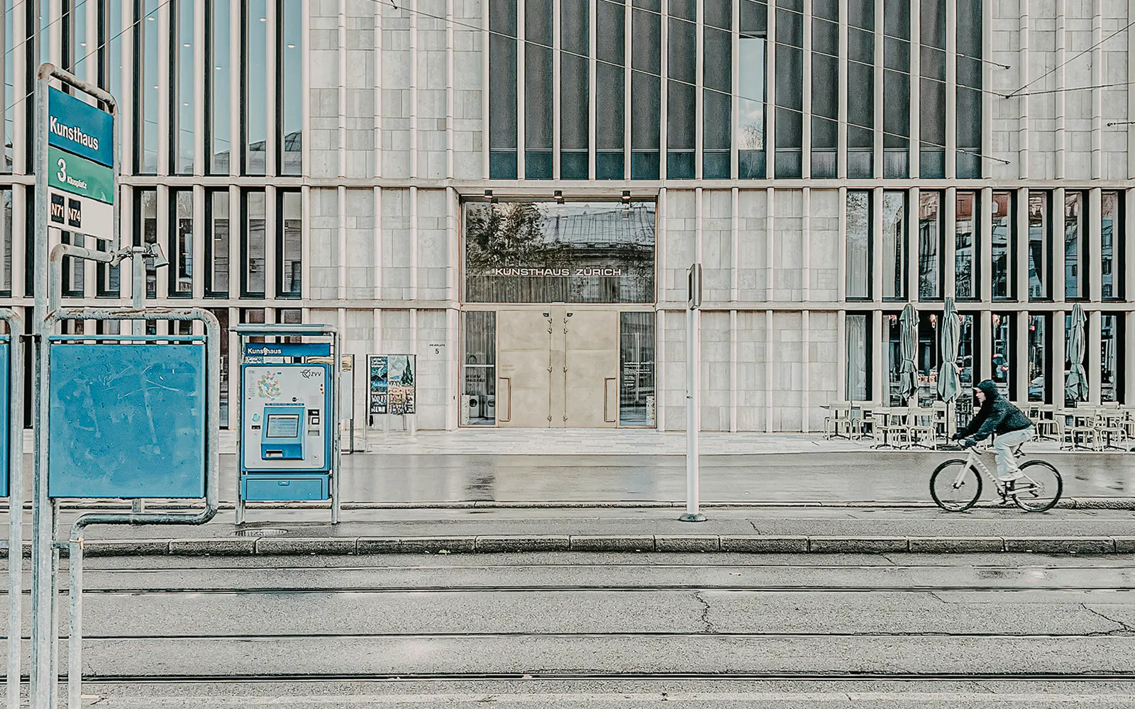 Kunsthaus Zurich exterior with cyclist and tram stop in foreground.