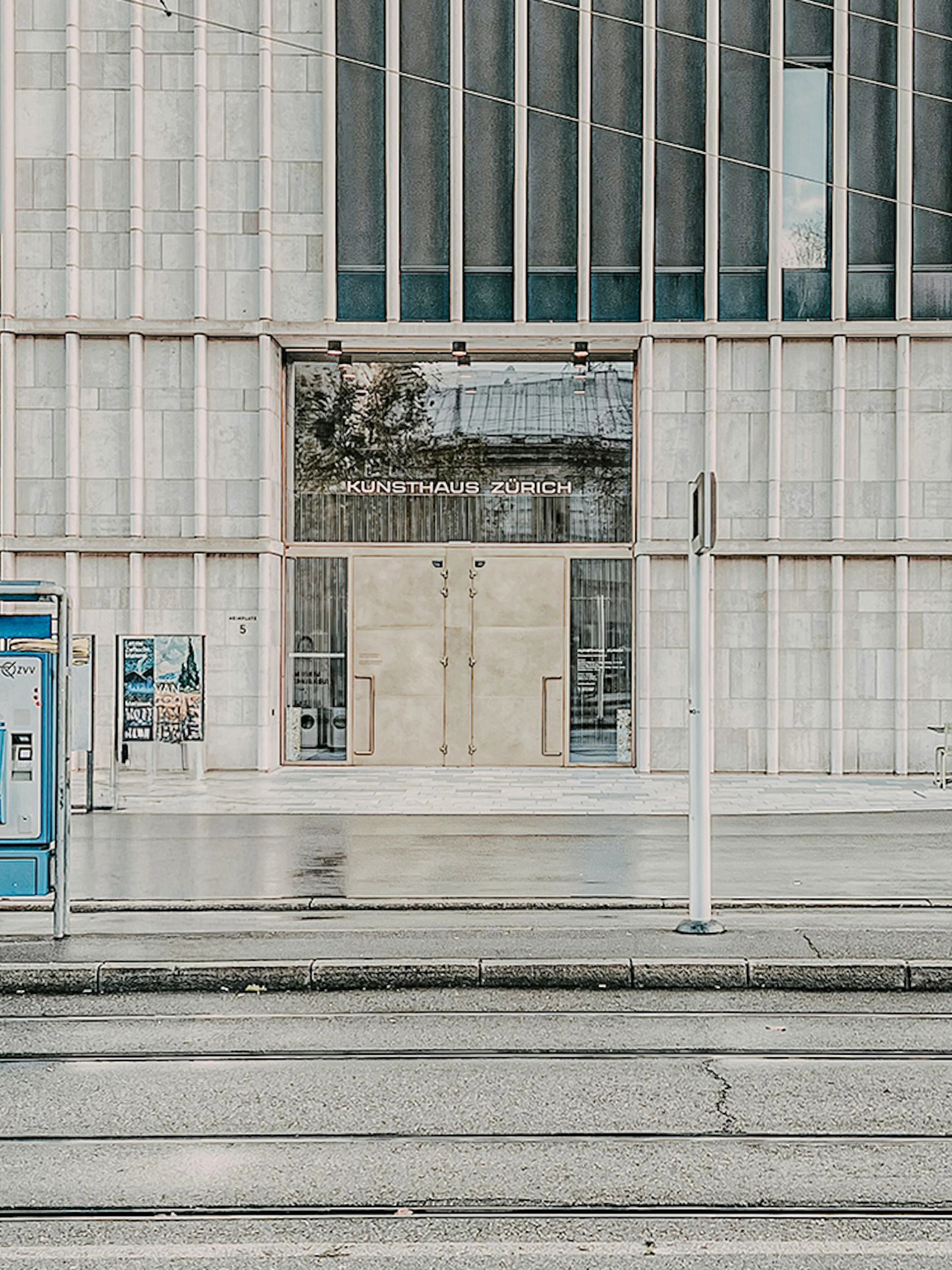 Kunsthaus Zurich exterior with cyclist and tram stop in foreground.