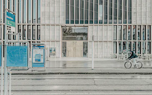 Kunsthaus Zurich exterior with cyclist and tram stop in foreground.