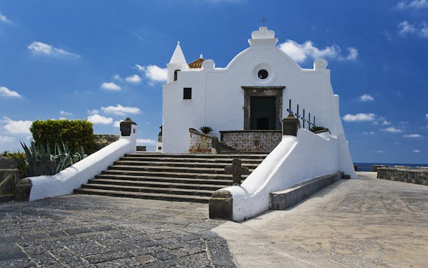 White church on Ischia island with blue sky, part of Naples day trip.